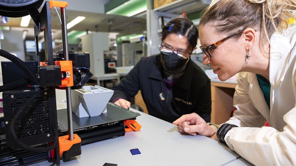 Aldridge and staff working on 3D printer